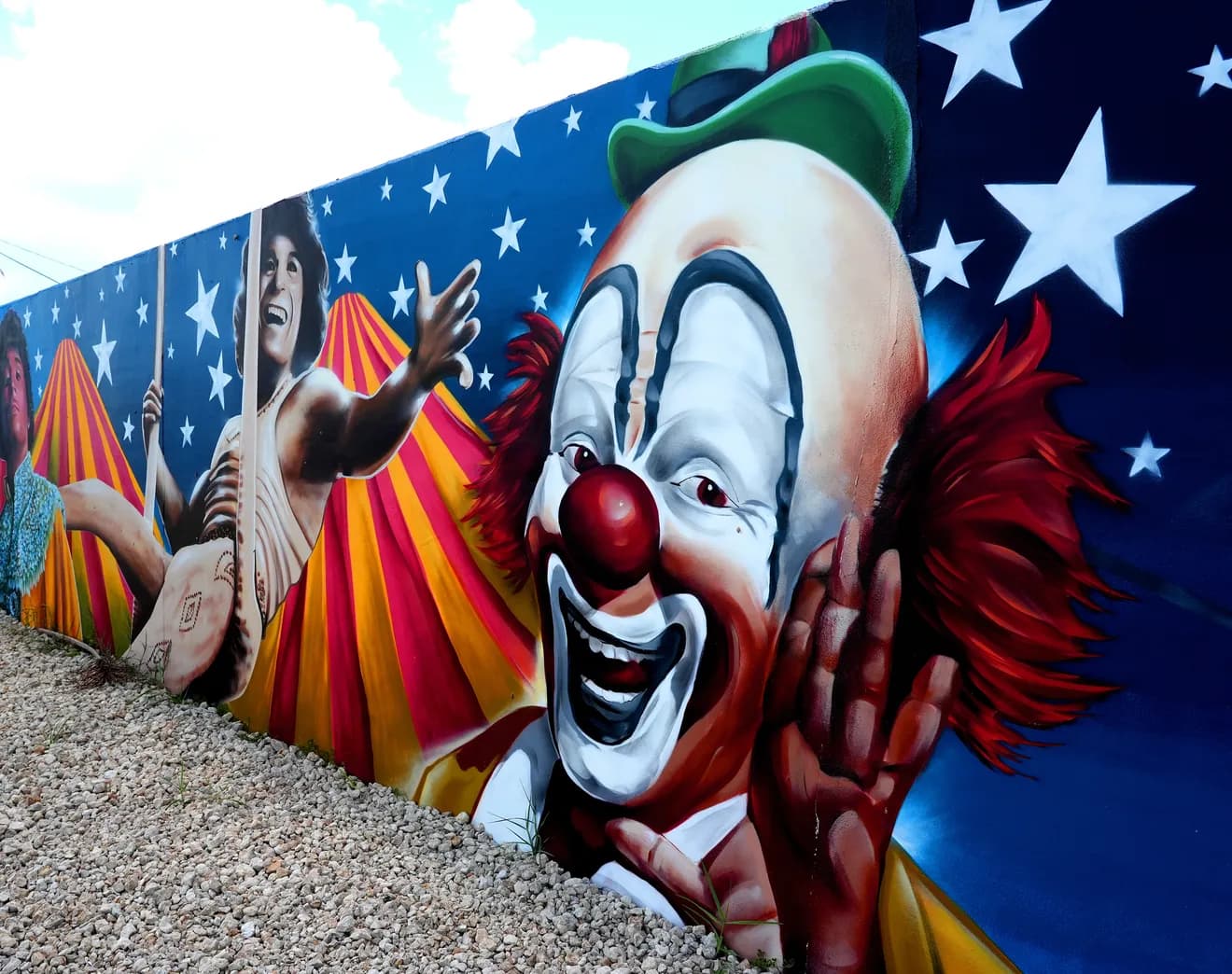 Circus themed mural with clown performer and circus tent stripes painted by Mark Francis of Bulk Styles