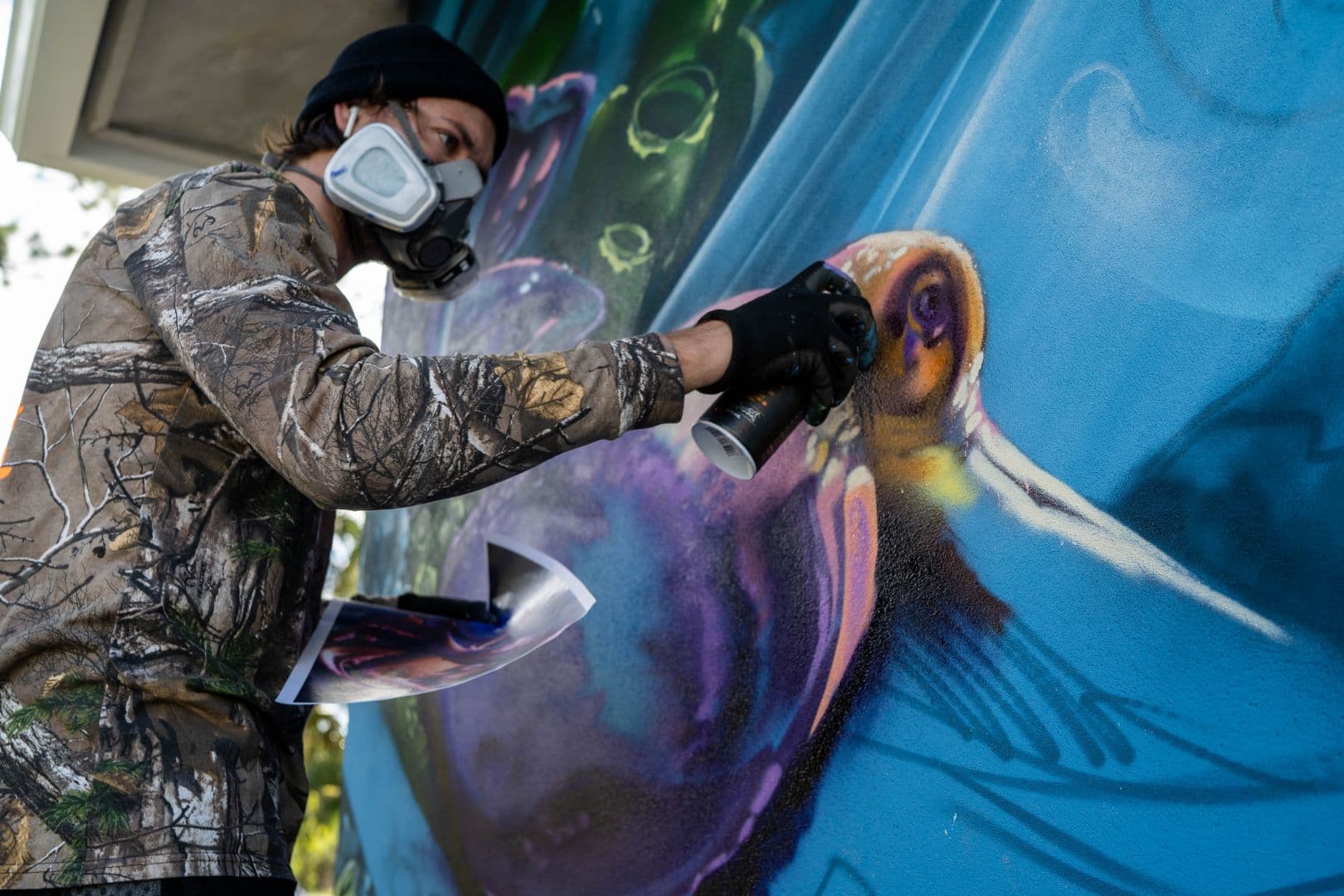 Mark Francis of Bulk Styles spray painting a large scale mural